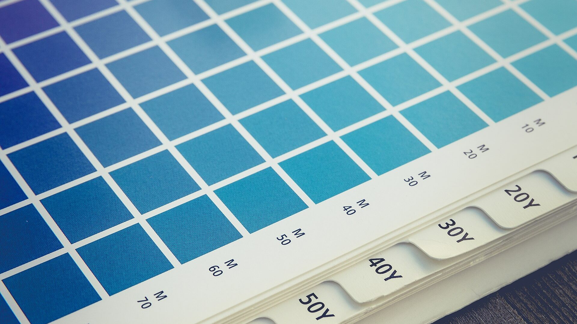 Pantone-style color swatch book with a loupe for color matching