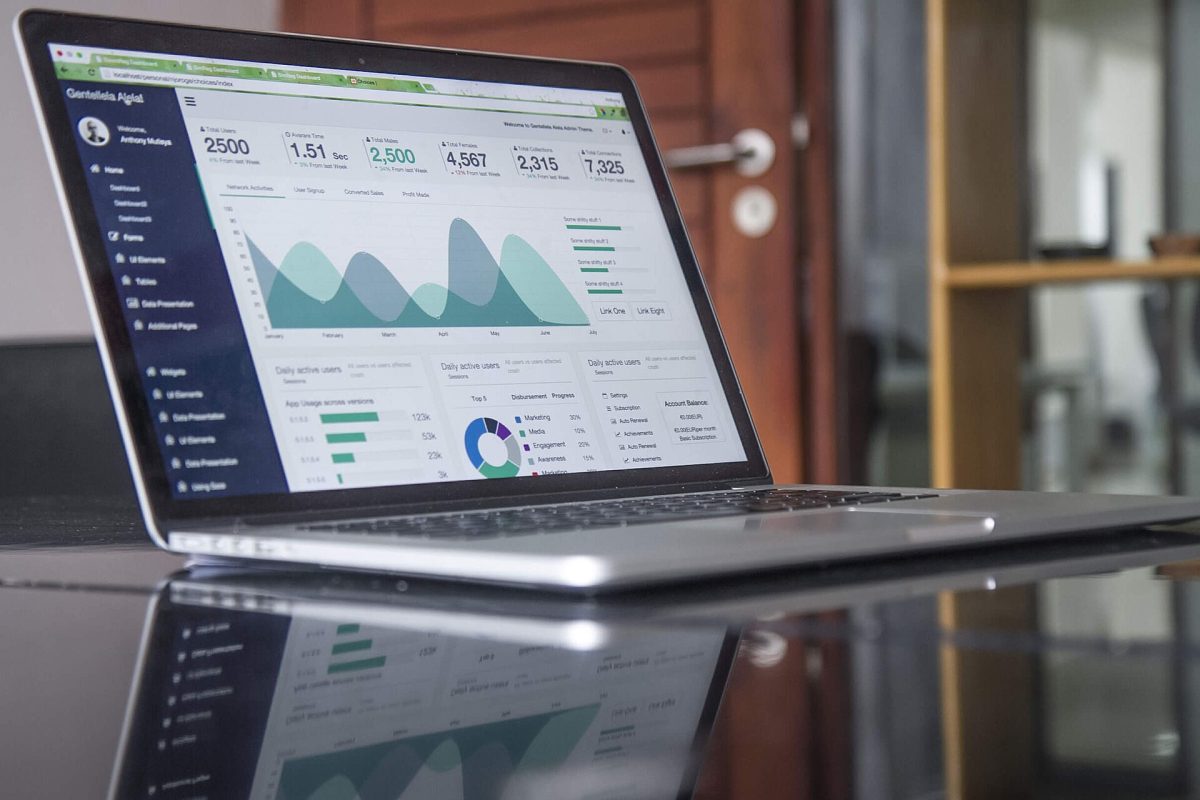Laptop screen showing a colorful analytics dashboard with charts